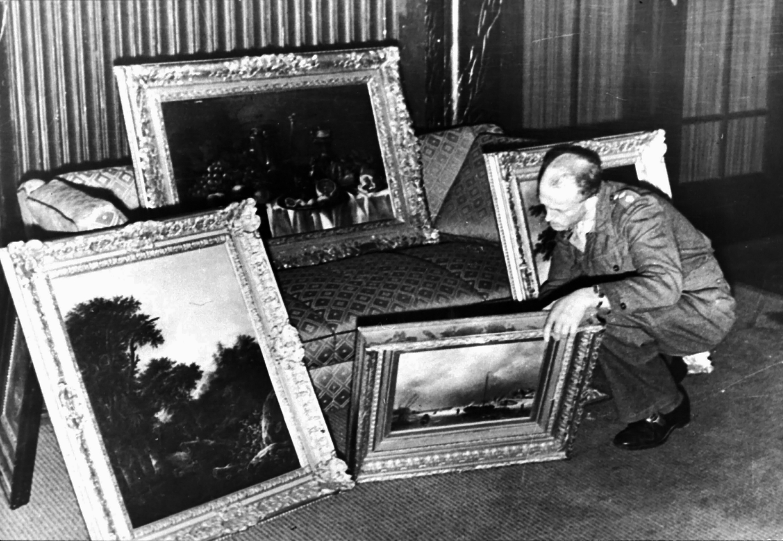 Een Engelse officier bekijkt kunstschatten in het huis van een hoge Nazi-officer te Hannover, waaronder ook Nederlandse werken